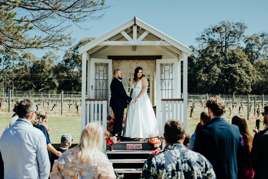 A couple is getting married on the porch of Big Love Tiny Chapel at Hay Shed Hill in Margaret River